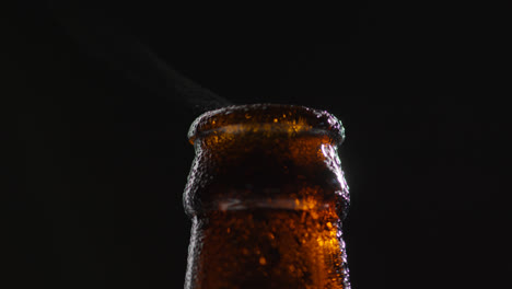 Close-Up-Of-Condensation-Droplets-On-Neck-Of-Revolving-Bottle-Of-Cold-Beer-Or-Soft-Drink-With-Water-Vapour-After-Opening